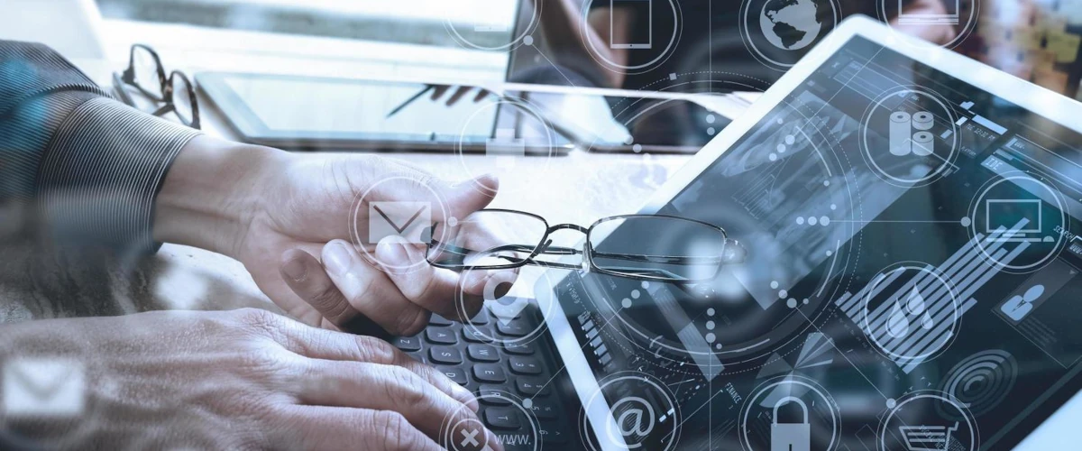 person wearing glasses working on a laptop