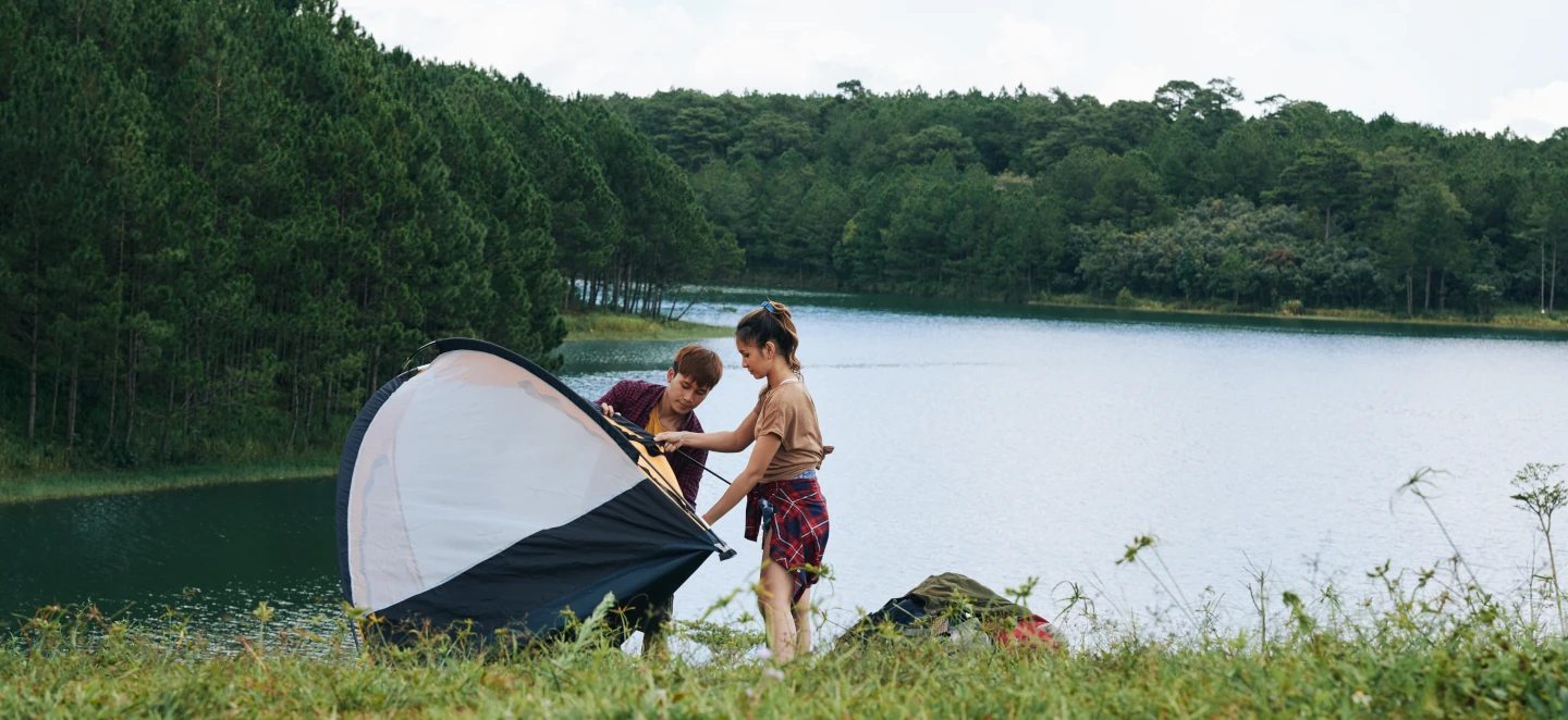 Banner people setting up a tent on the river