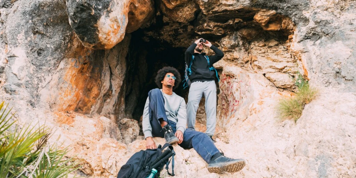 Two people entering a cave