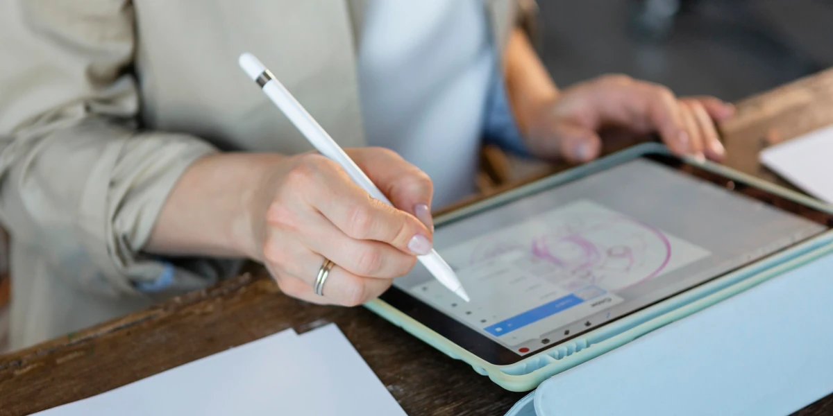 Person writing on tablet