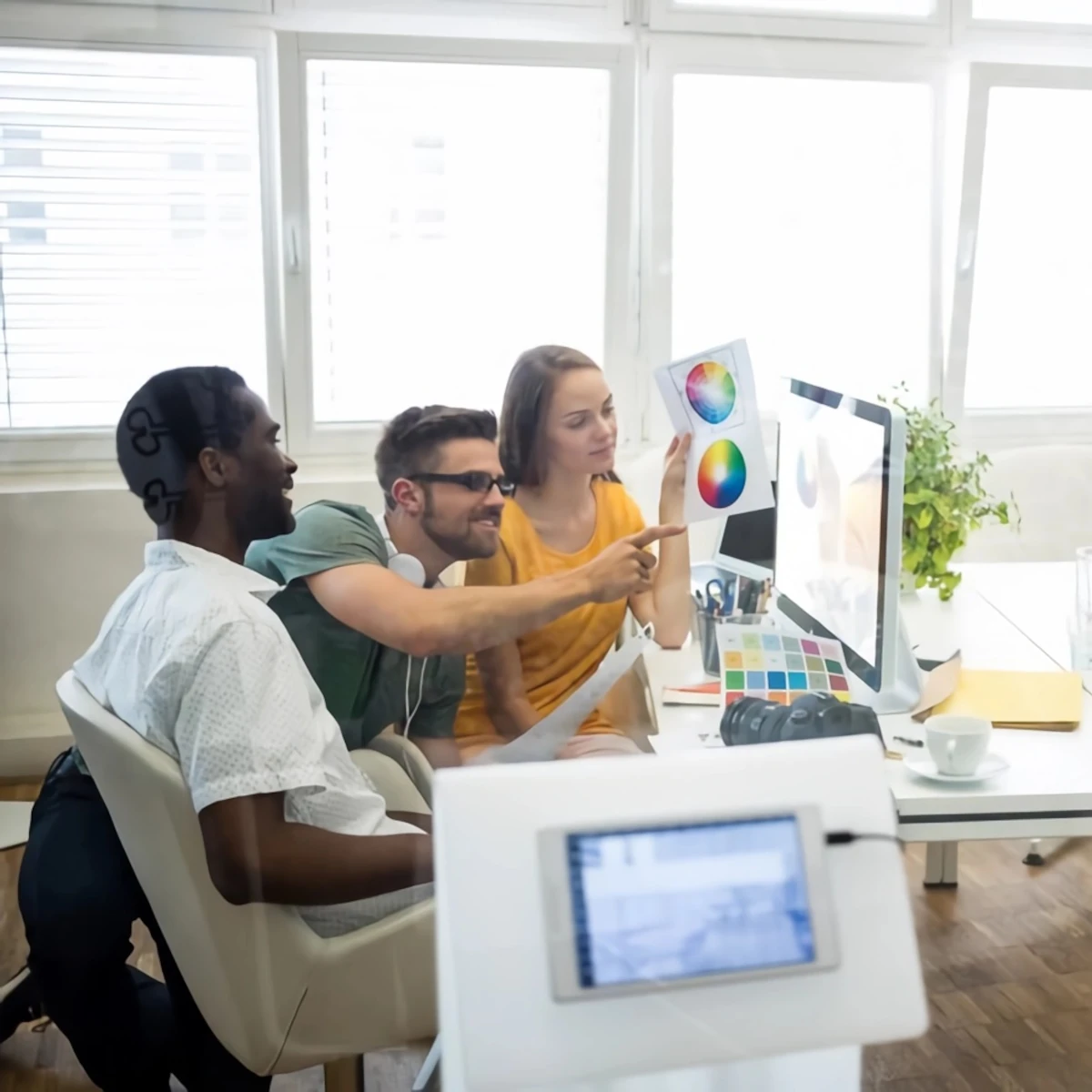 Coworkers analyzing blueprints and looking at a PC