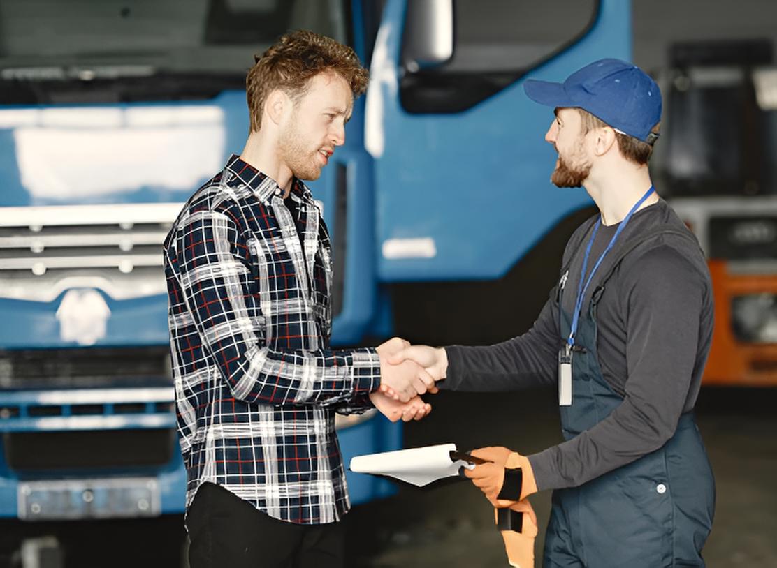 men-shaking-hands-in-front-of-a-truck