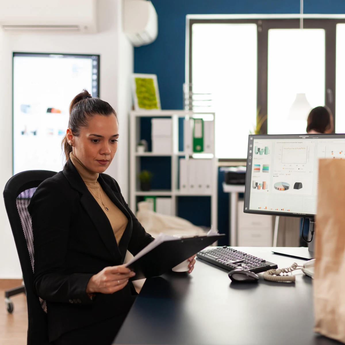 the businesswoman in the corporate launch of the office analyzing documents graphic looking at the clipboard
