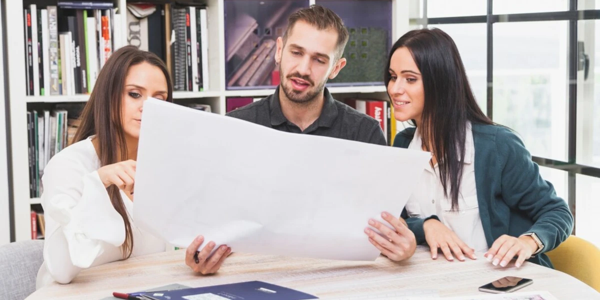 Cheerful colleagues working with a plan