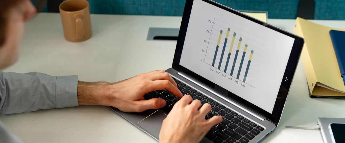 side view of a man typing on a laptop